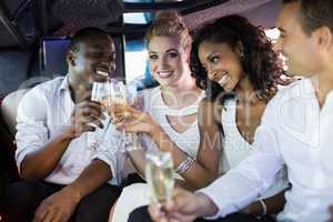 Well dressed people drinking champagne in a limousine