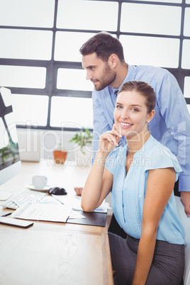 Businesswoman smiling while sitting by colleague Businesswoman smiling while sitting by colleague