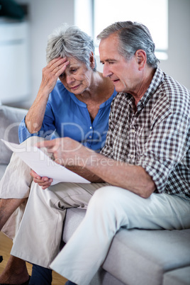 Worried senior couple checking the bills