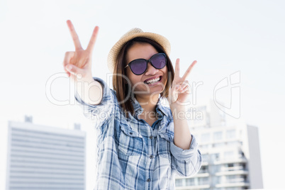 Happy young woman doing a v sign