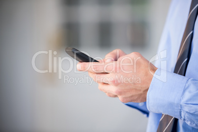 Cropped hand of businessman using mobile phone