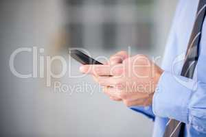 Cropped hand of businessman using mobile phone