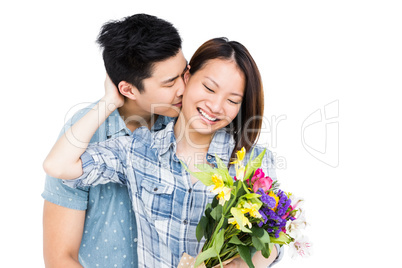Man kissing woman and giving her flowers