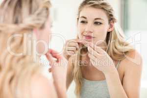 Concerned young woman looking in mirror