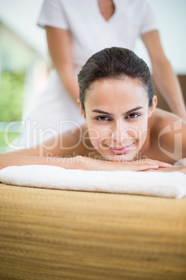 Portrait of young woman receiving massage at spa