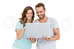 Happy young couple using laptop