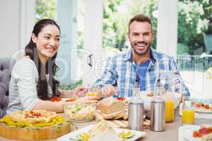 Smiling couple sitting at dining table