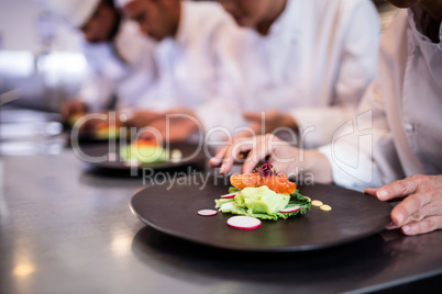 Close-up of chef decorating food plate