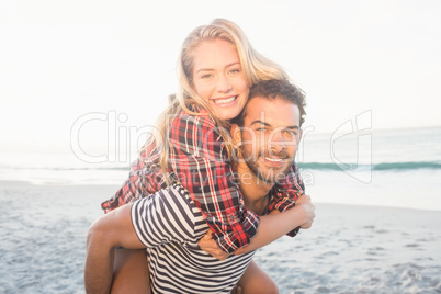 Portrait of a young man piggybacking beautiful woman