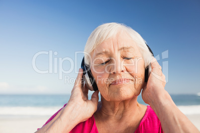 Senior woman listening music with headphone