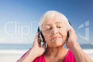 Senior woman listening music with headphone