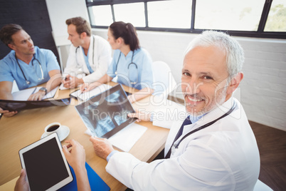 Happy doctor holding a x-ray report in conference room