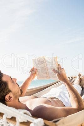 Man reading book in hammock