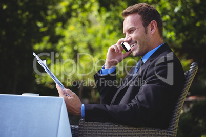 Handsome businessman on the phone and reading the menu