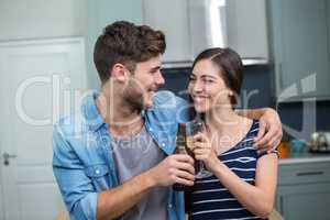 Young friends toasting drinks at home