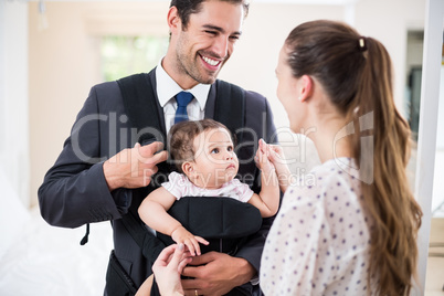 Happy father carrying baby with mother