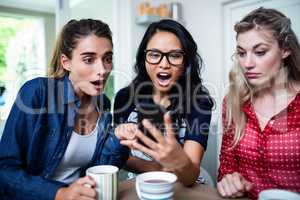 Female friends shocked while looking in mobile phone