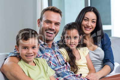 Family sitting on sofa and smiling