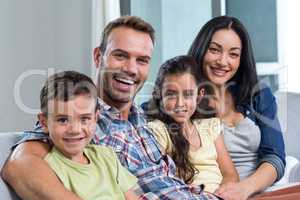 Family sitting on sofa and smiling