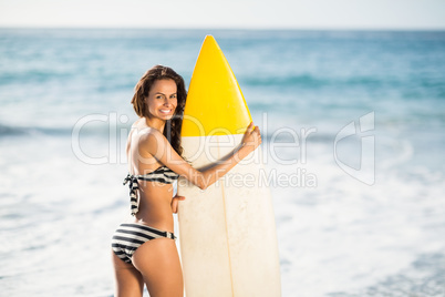 Woman holding surfboard at the beach