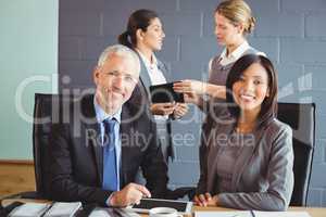 Businessman and businesswoman sitting in conference room