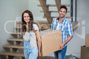Portrait of cheerful couple with cardboard boxes