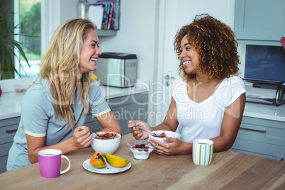 Female friends having breakfast at kitchen table