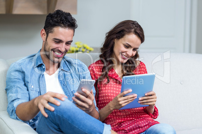 Smiling couple using technology