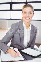 Young businesswoman with documents sitting at desk