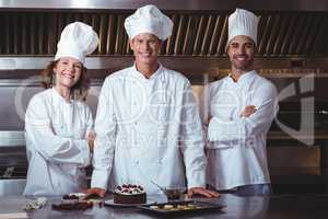 Chefs happy and proud to present the cake they just made