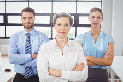 Portrait of confident business people by desk in office