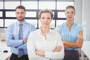 Portrait of confident business people by desk in office