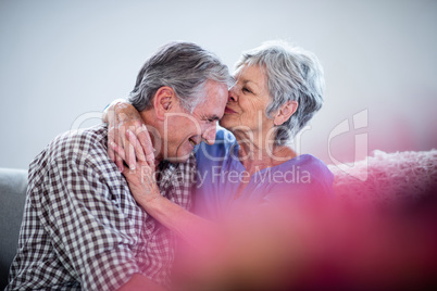 Senior woman embracing and kissing on mans forehead