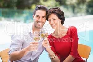 Portrait of smiling couple toasting white wine