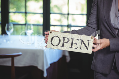 Businesswoman holding open sign