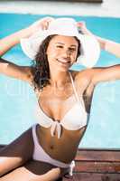 Portrait of happy woman wearing white hat and bikini relaxing by