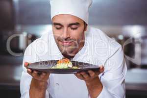 Male chef with eyes closed smelling food