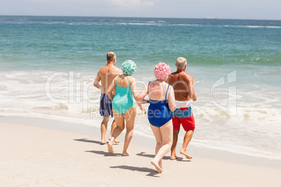 Senior friends running into water