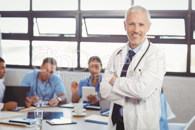 Portrait of male doctor standing with arms crossed