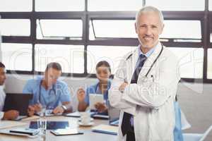 Portrait of male doctor standing with arms crossed