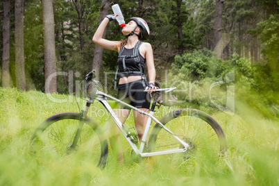 Woman drinking water next to her bike