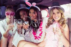 Frivolous women drinking champagne in a limousine