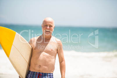 Senior man carrying surfboard Senior man carrying surfboard