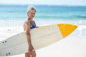 Mature woman posing with a surfboard