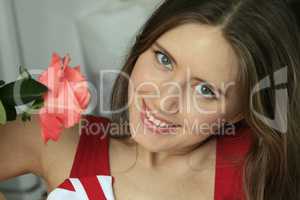 Portrait of attractive gentle woman with beautiful red rose
