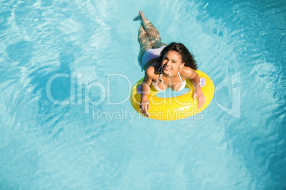 Portrait of woman in white bikini floating on inflatable tube in