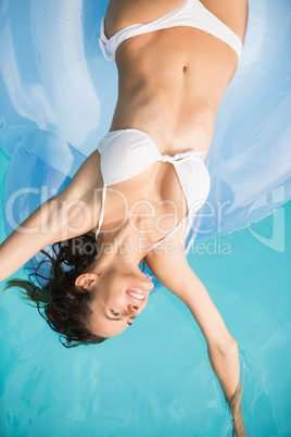 Pretty young woman relaxing on inflatable ring