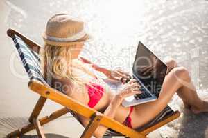 Woman sitting on a armchair and using a laptop