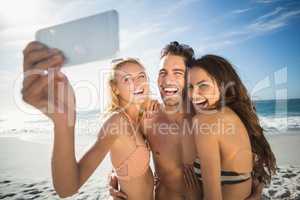 Happy friends taking selfie on the beach