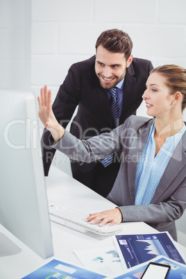 Business people discussing over computer